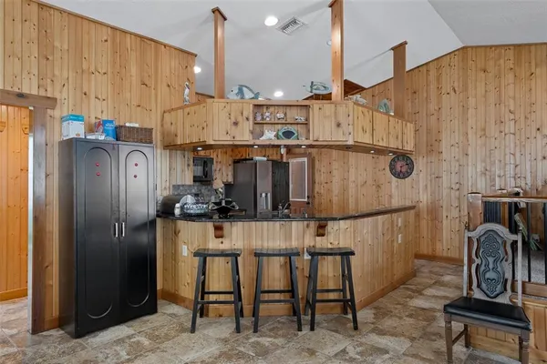 a view of a kitchen with fridge and furniture