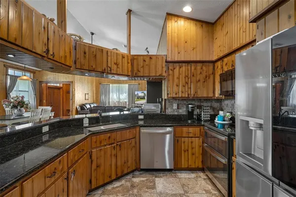 a kitchen with stainless steel appliances granite countertop a sink and cabinets