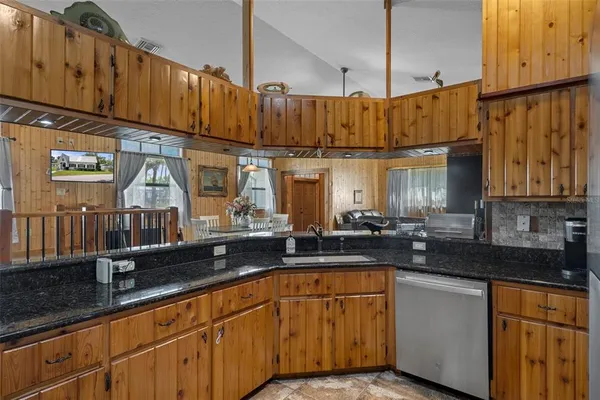 a kitchen with stainless steel appliances granite countertop a sink stove and cabinets
