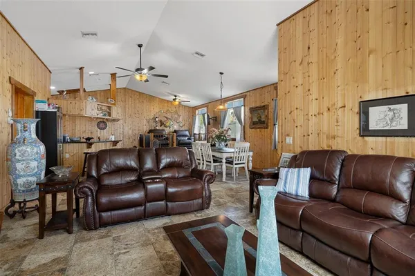 a living room with furniture a ceiling fan and a rug