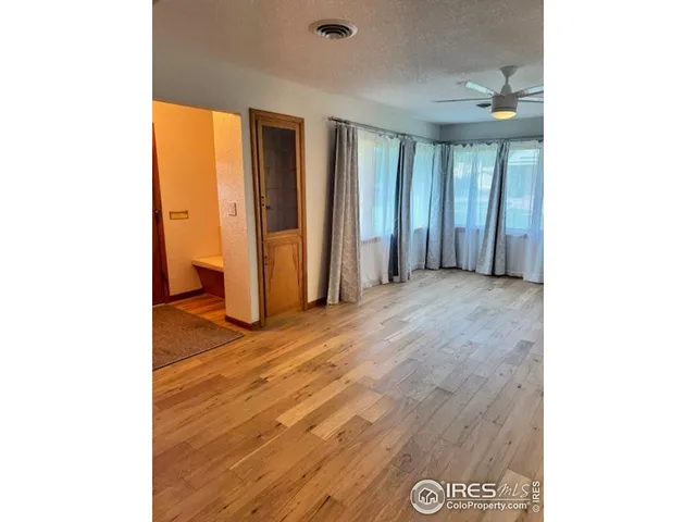 a view of an empty room with wooden floor