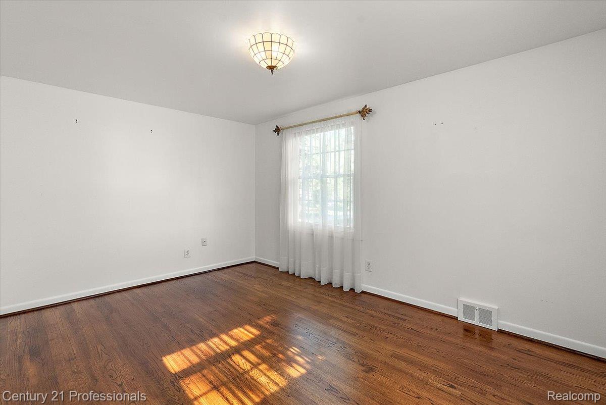 633 Foxhall Road Bloomfield Hills, MI 48304 - Photo 51 of 61 Interior space featuring wood-finish flooring, white walls, and a window with sheer curtains