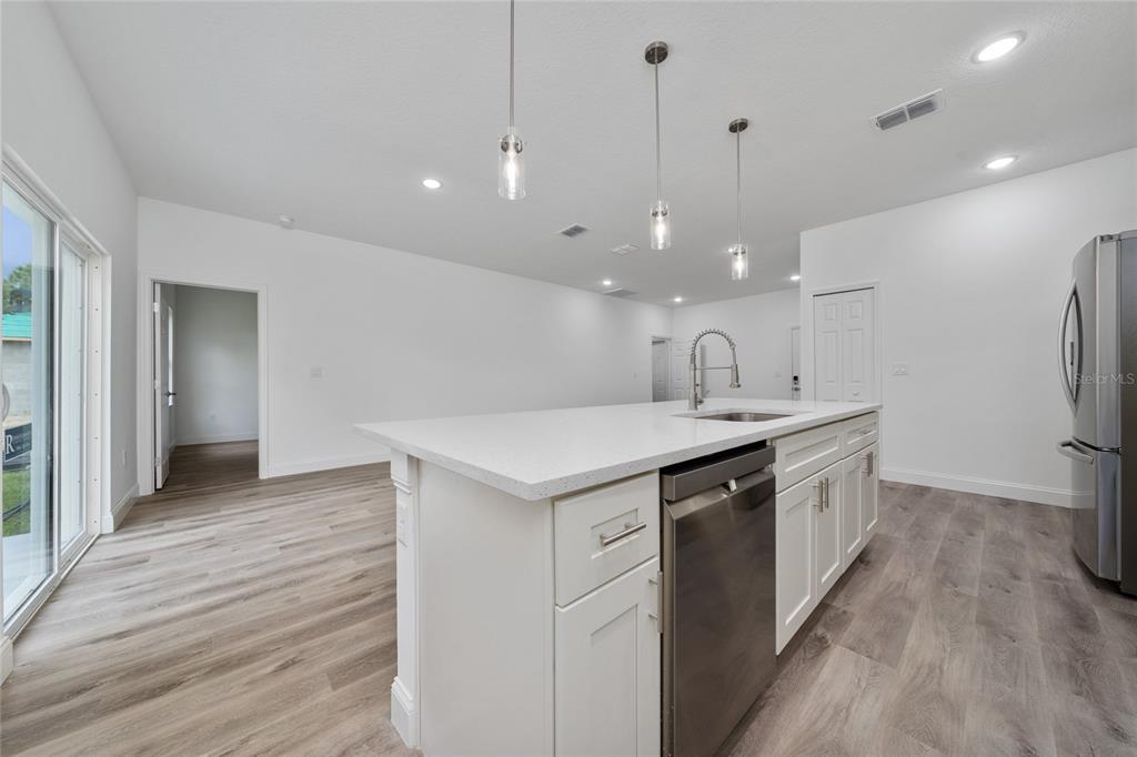 8922 Southwest 135th Street Road Ocala, FL 34473 - Photo 13 of 44 a kitchen with a sink a refrigerator and wooden floor