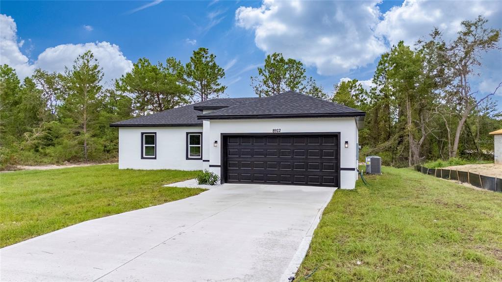 8922 Southwest 135th Street Road Ocala, FL 34473 - Photo 37 of 44 a front view of a house with a yard and garage