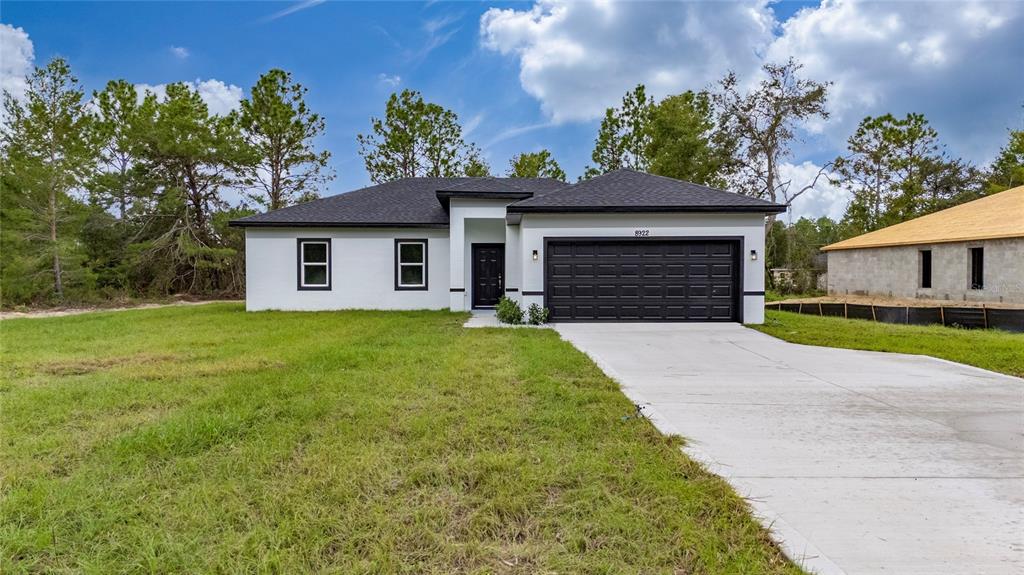 8922 Southwest 135th Street Road Ocala, FL 34473 - Photo 38 of 44 a front view of a house with a yard and garage