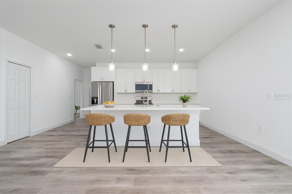 8922 Southwest 135th Street Road Ocala, FL 34473 - Photo 9 of 44 a kitchen with stainless steel appliances kitchen island granite countertop a table chairs sink and cabinets