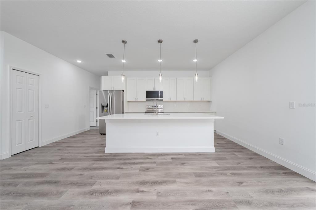 8922 Southwest 135th Street Road Ocala, FL 34473 - Photo 10 of 44 a view with kitchen island a sink wooden floor and kitchen island