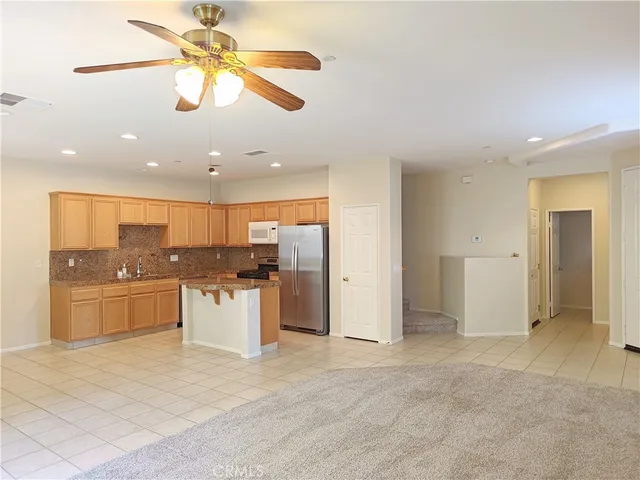 a kitchen with a refrigerator sink and cabinets