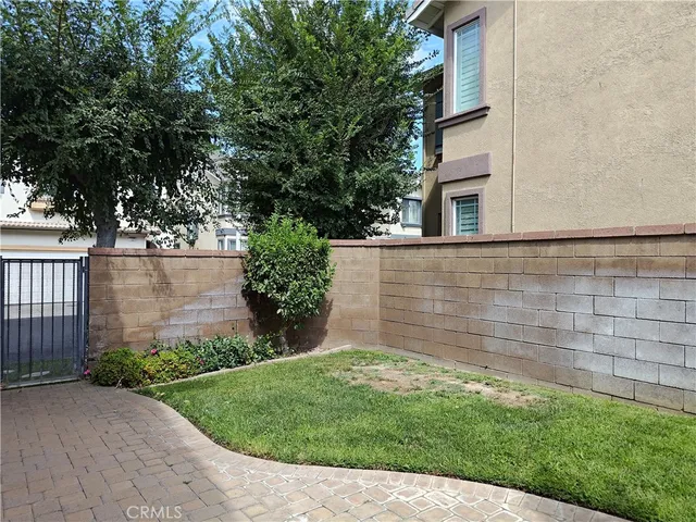 a view of a backyard with plants and large trees