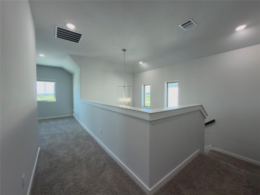 120 Millwood Road Lavon, TX 75166 - Photo 16 of 34 Upper-level hallway featuring a contemporary chandelier, recessed lighting, carpet flooring, and multiple windows providing ambient light