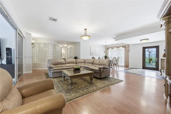 a living room with furniture and a wooden floor
