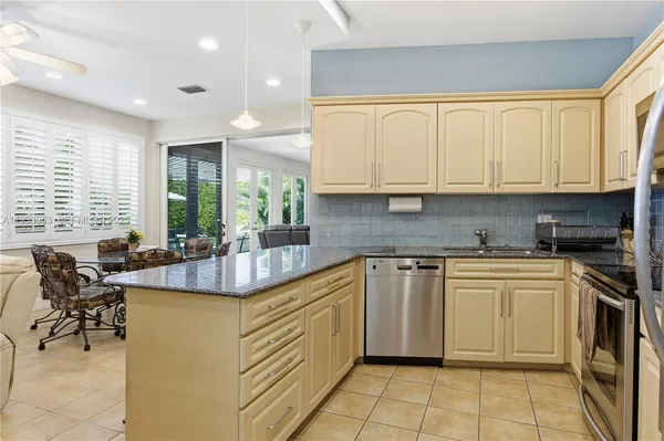 a kitchen with stainless steel appliances granite countertop a sink and a white cabinets