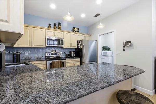 a kitchen with stainless steel appliances granite countertop a sink a stove and a refrigerator
