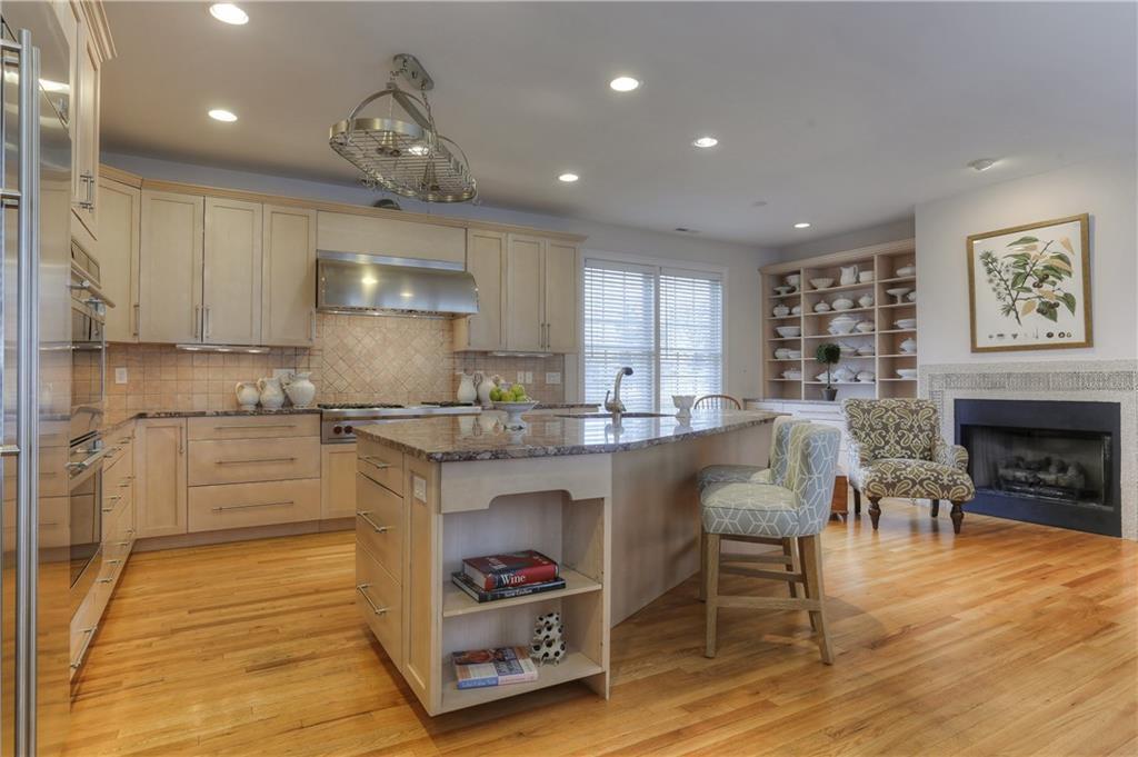 655 Reef Road, Unit 655 Fairfield, CT 06824 - Photo 1 of 1 a kitchen with granite countertop cabinets a dining table and chairs with wooden floor