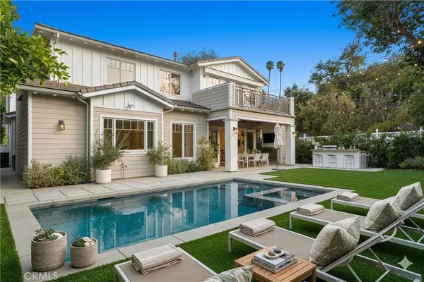a view of a house with a backyard patio and swimming pool