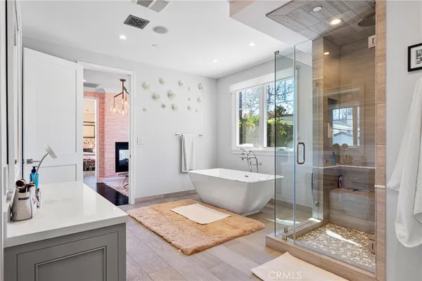 a spacious bathroom with a tub sink and mirror