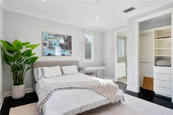 a bedroom with a large bed and a potted plant