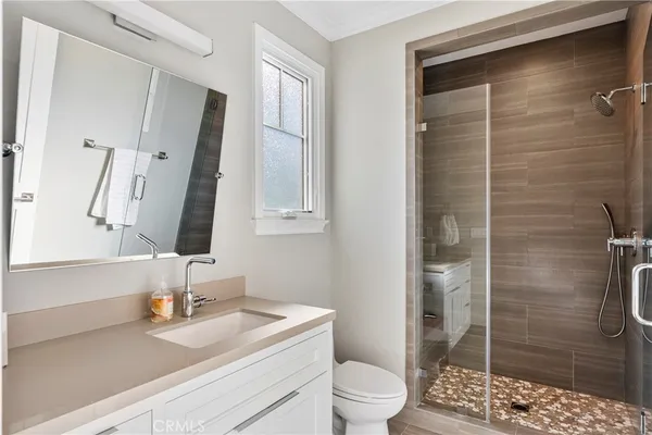 a bathroom with a sink a toilet and shower