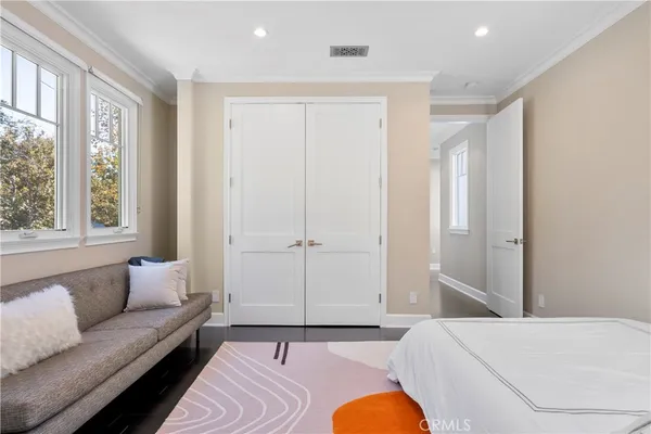 a bedroom with a large bed couch and a window