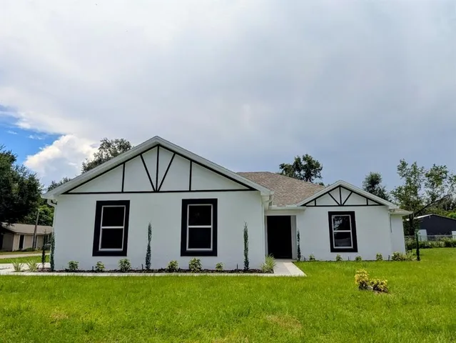 a front view of a house with a yard and trees