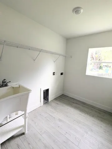 an empty room with a wooden cabinet and windows