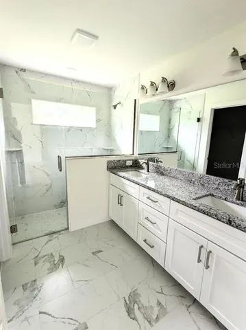 a spacious bathroom with a granite countertop sink a mirror and a