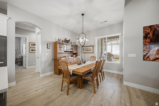 2829 East 1880th Street South St. George, UT 84790 - Photo 16 of 54 Dining room with light wood-style flooring, arched walkways, and a chandelier