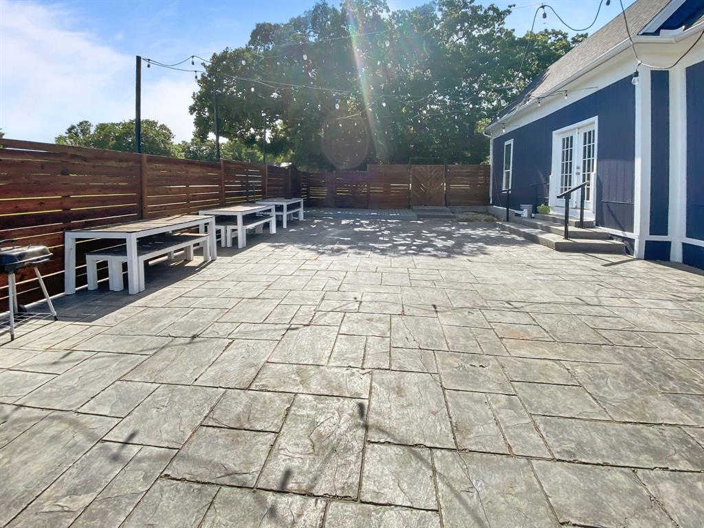 815 Stonecrest Road Argyle, TX 76226 - Photo 12 of 17 Expansive stamped concrete patio with a dark wood privacy fence, and a dark blue exterior with white trim