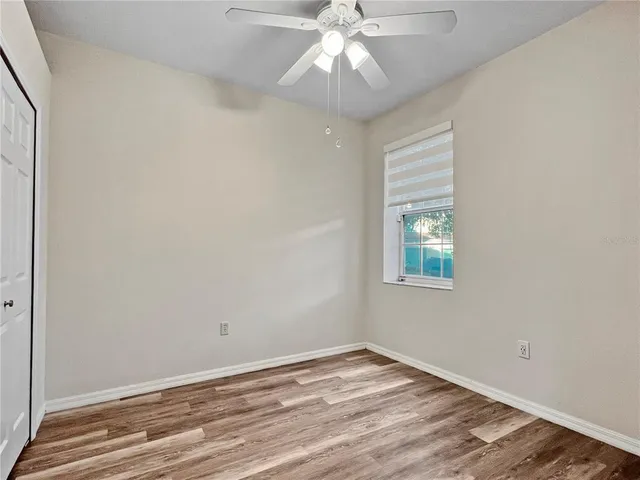 an empty room with a window and wooden floor
