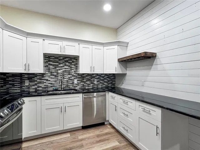 a kitchen with granite countertop white cabinets and white appliances