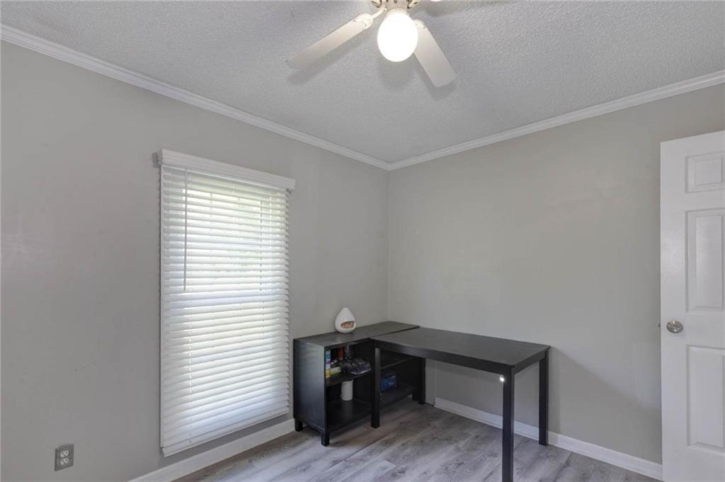 184 Floyd Road Pine Mountain, GA 31822 - Photo 3 of 27 Light gray wall paint, crown molding, wood-finish flooring, ceiling fan with integrated lighting, and a paneled door