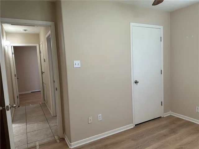 an empty room with wooden floor and mirror