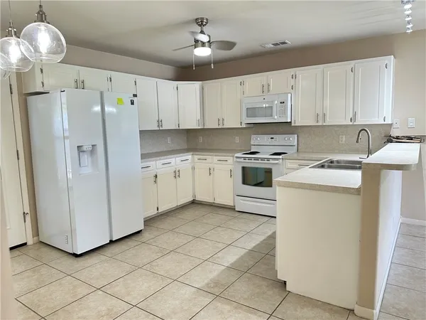 a kitchen with cabinets stainless steel appliances and a window