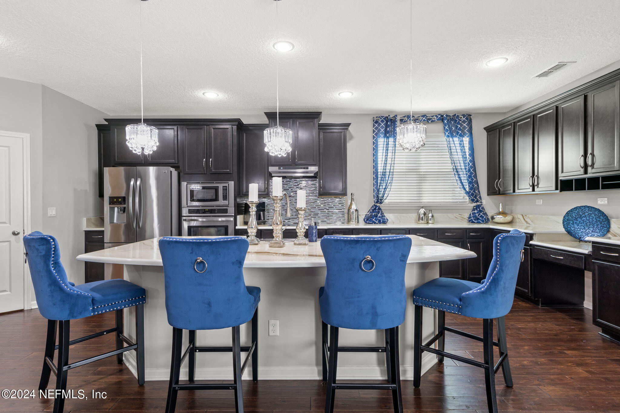 4459 Quail Hollow Road Orange Park, FL 32065 - Photo 11 of 37 a kitchen with stainless steel appliances kitchen island granite countertop a kitchen island a table and chairs