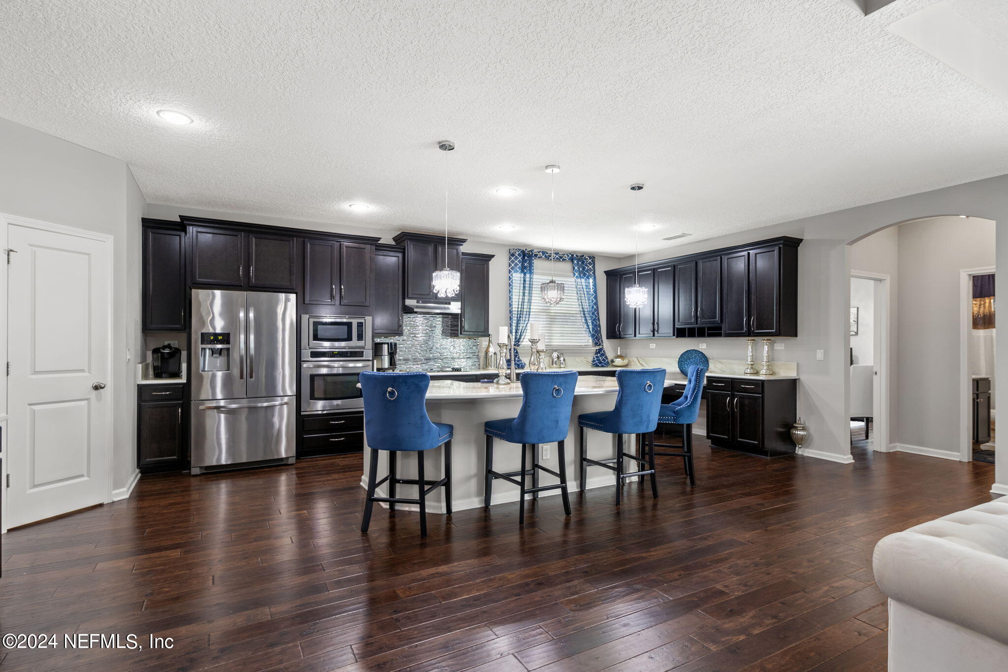 4459 Quail Hollow Road Orange Park, FL 32065 - Photo 9 of 37 a kitchen with stainless steel appliances wooden floor and dining table