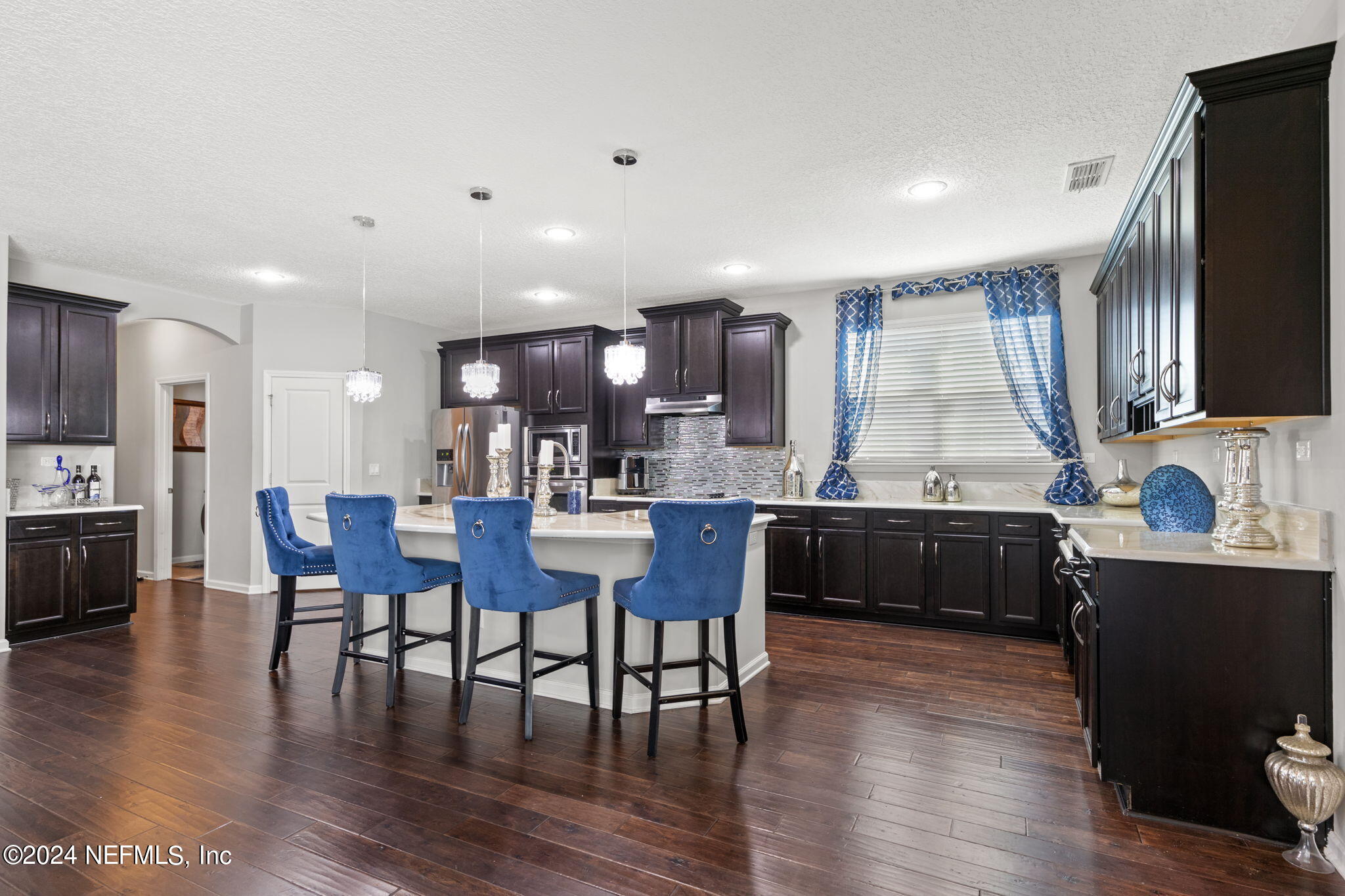 4459 Quail Hollow Road Orange Park, FL 32065 - Photo 10 of 37 a kitchen with a table chairs refrigerator and cabinets