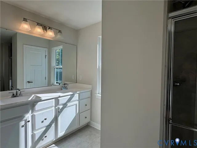 a spacious bathroom with a double vanity sink and a mirror