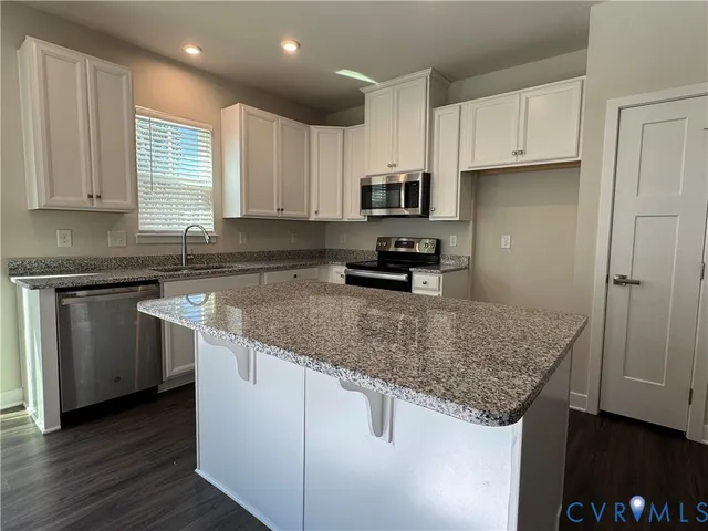 a kitchen with stainless steel appliances granite countertop a sink stove and microwave