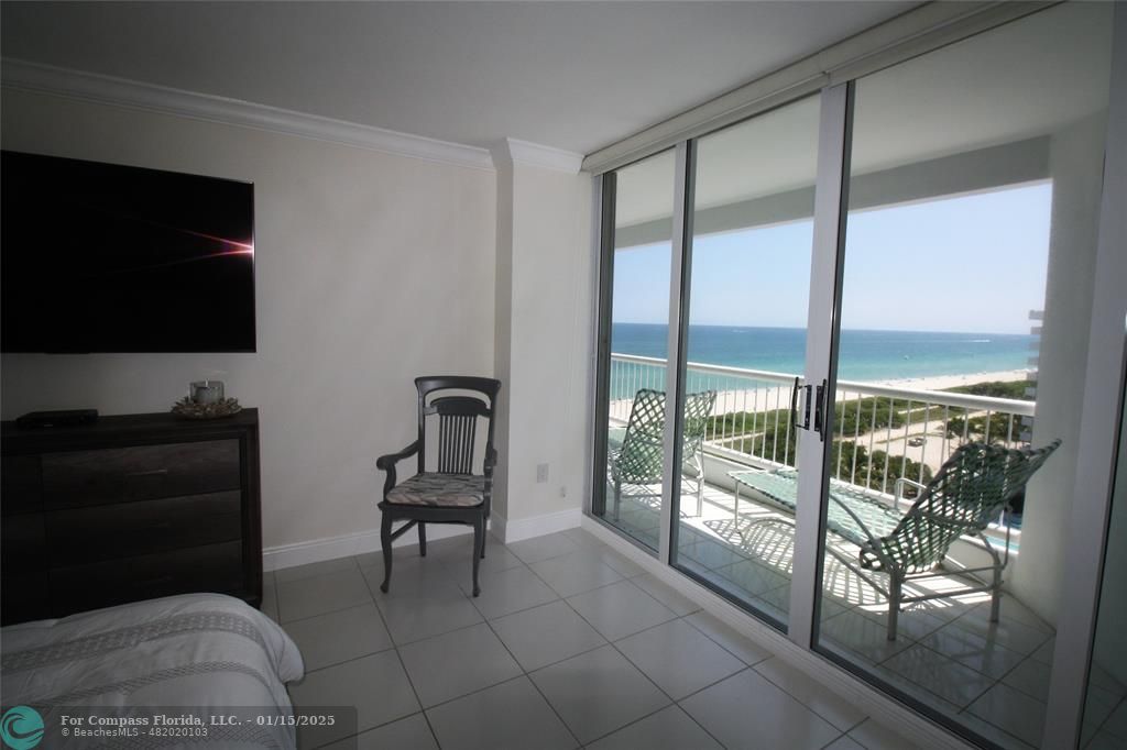 9341 Collins Avenue, Unit 1003 Surfside, FL 33154 - Photo 13 of 24 a living room with furniture and a flat screen tv
