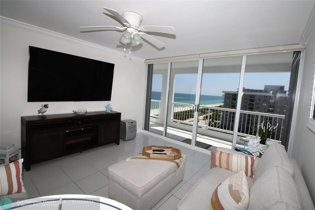 9341 Collins Avenue, Unit 1003 Surfside, FL 33154 - Photo 3 of 24 a living room with furniture and a flat screen tv