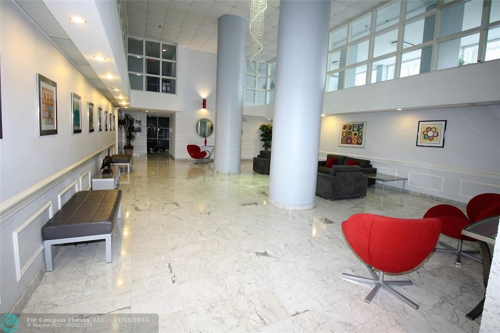 9341 Collins Avenue, Unit 1003 Surfside, FL 33154 - Photo 10 of 24 a living room with furniture gym equipment and a rug