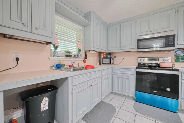 a kitchen with stainless steel appliances granite countertop a sink a stove and cabinets