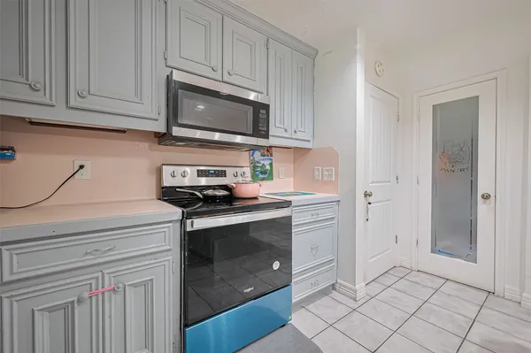 a kitchen with stainless steel appliances granite countertop a stove a microwave and a white cabinets