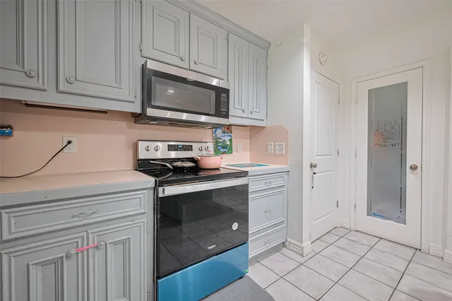 a kitchen with stainless steel appliances granite countertop a stove a microwave and a white cabinets