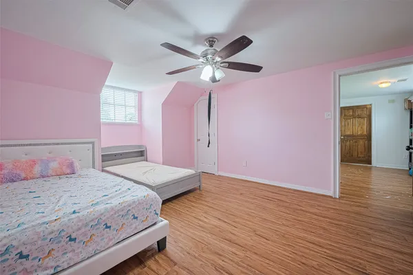 a bedroom with a bed chandelier and a window