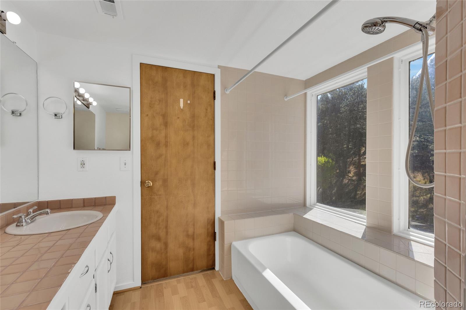 23537 Genesee Village Road Golden, CO 80401 - Photo 17 of 37 a bathroom with a granite countertop sink mirror and shower