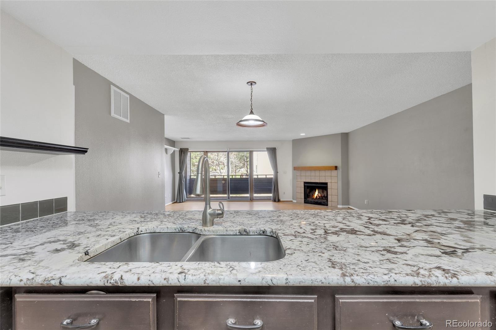 23537 Genesee Village Road Golden, CO 80401 - Photo 5 of 37 a kitchen with sink granite counter tops and a fireplace