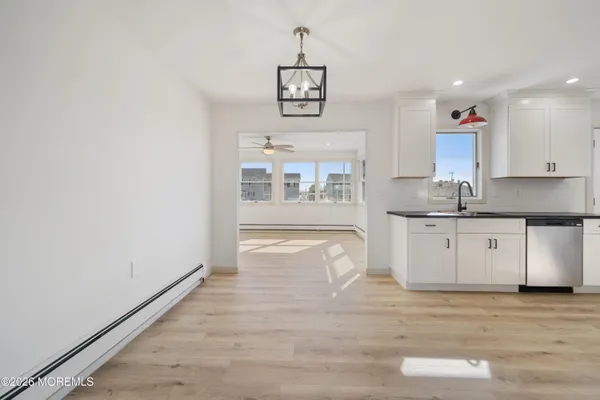 a kitchen with stainless steel appliances granite countertop a stove a sink and white cabinets