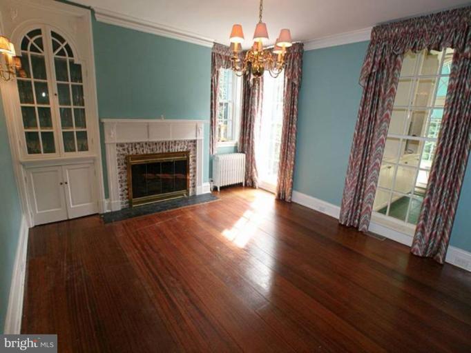 105 Taplow Road Baltimore, MD 21212 - Photo 3 of 14 a view of an empty room with wooden floor fireplace and a window