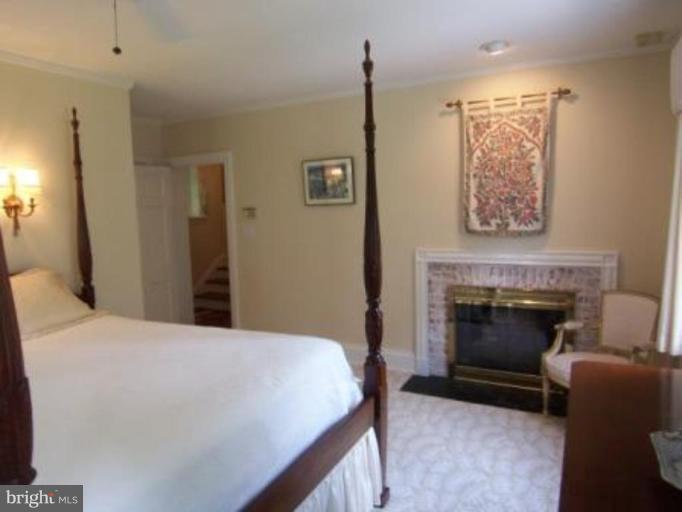 105 Taplow Road Baltimore, MD 21212 - Photo 9 of 14 a bedroom with a bed and a fireplace